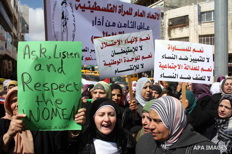 Palestinian women hold placards to mark the International Women Day in the West Bank city of Hebron, on March 08 2011.Photo by Najeh Hashlamoun