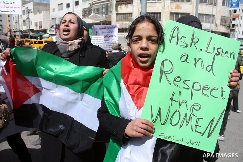 Palestinian women hold placards to mark the International Women Day in the West Bank city of Hebron, on March 08 2011.Photo by Najeh Hashlamoun