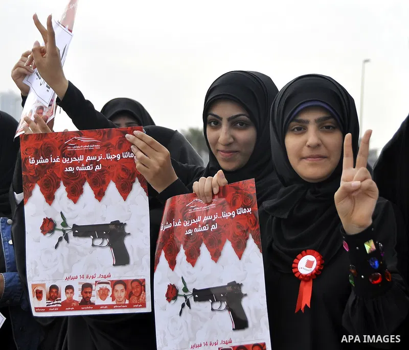 Bahraini anti-government women protesters wave flags and hold signs Tuesday, March 8, 2011, in Manama, Bahrain, to mark the International Woman Day. Photo by Ammar A.rasool