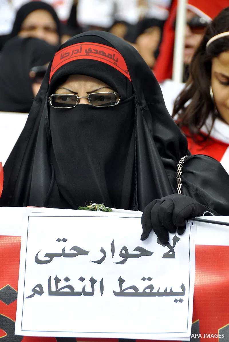 Bahraini anti-government women protesters wave flags and hold signs Tuesday, March 8, 2011, in Manama, Bahrain, to mark the International Woman Day. Photo by Ammar A.rasool