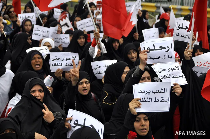 Bahraini anti-government women protesters wave flags and hold signs Tuesday, March 8, 2011, in Manama, Bahrain, to mark the International Woman Day. Photo by Ammar A.rasool
