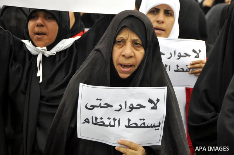 Bahraini anti-government women protesters wave flags and hold signs Tuesday, March 8, 2011, in Manama, Bahrain, to mark the International Woman Day. Photo by Ammar A.rasool