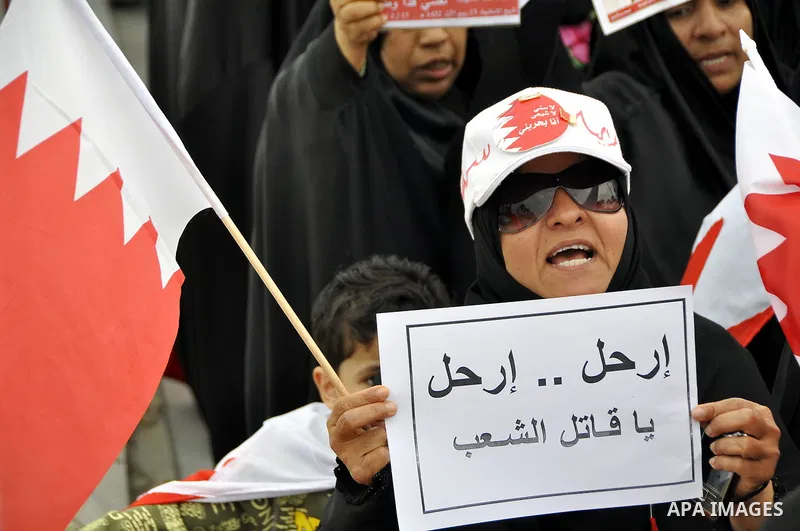 Bahraini anti-government women protesters wave flags and hold signs Tuesday, March 8, 2011, in Manama, Bahrain, to mark the International Woman Day. Photo by Ammar A.rasool