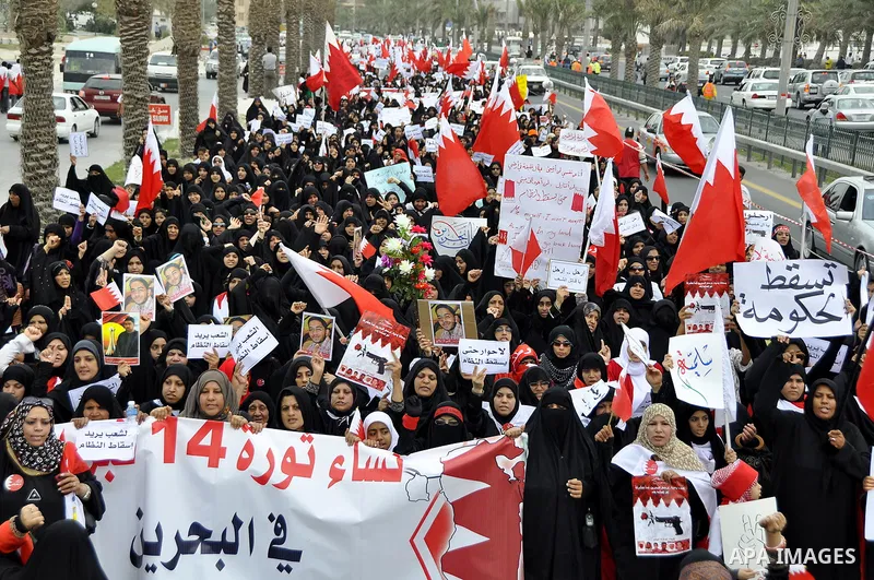 Bahraini anti-government women protesters wave flags and hold signs Tuesday, March 8, 2011, in Manama, Bahrain, to mark the International Woman Day. Photo by Ammar A.rasool