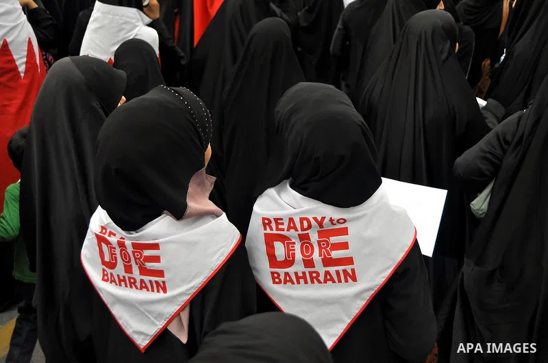 Bahraini anti-government women protesters wave flags and hold signs Tuesday, March 8, 2011, in Manama, Bahrain, to mark the International Woman Day. Photo by Ammar A.rasool