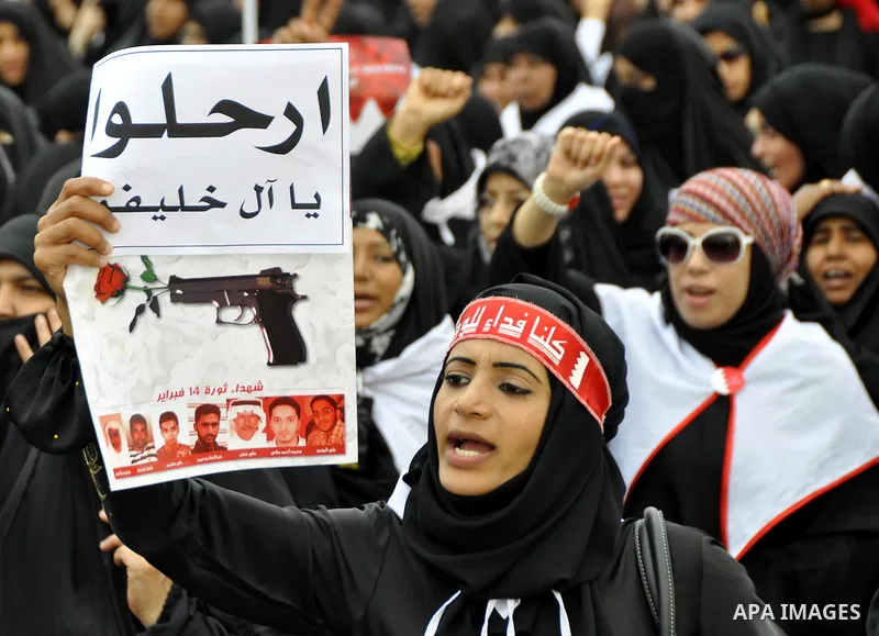 Bahraini anti-government women protesters wave flags and hold signs Tuesday, March 8, 2011, in Manama, Bahrain, to mark the International Woman Day. Photo by Ammar A.rasool