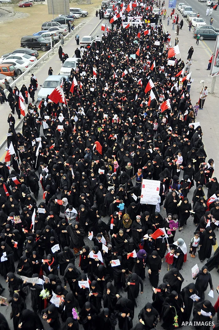 Bahraini anti-government women protesters wave flags and hold signs Tuesday, March 8, 2011, in Manama, Bahrain, to mark the International Woman Day. Photo by Ammar A.rasool