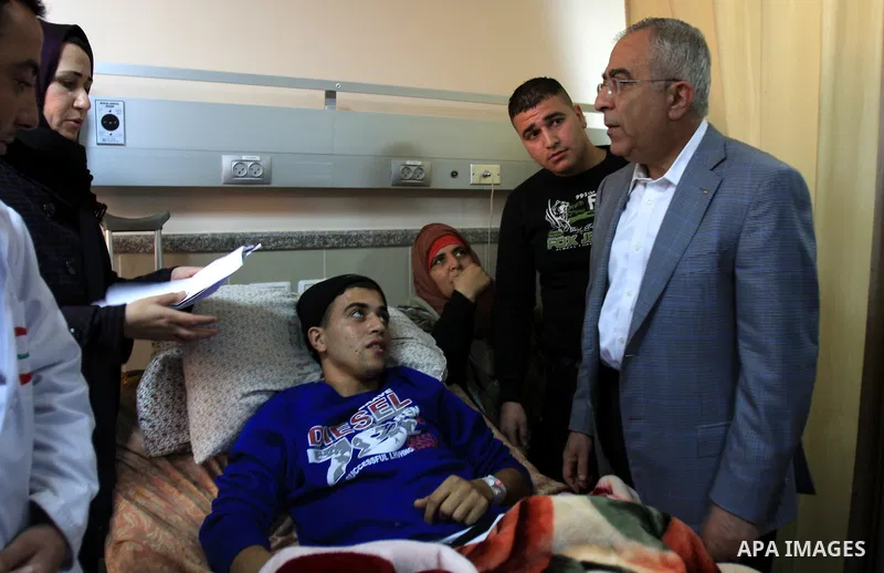 Palestinian Prime Minister Salam Fayyad visits the wounded Palestinians who injured during attack by Israeli settlers, at Rafidia hospital in the West Bank city of Nablus ,Tuesday, March 8, 2011. Jewish settlers opened f...