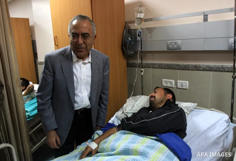 Palestinian Prime Minister Salam Fayyad visits the wounded Palestinians who injured during attack by Israeli settlers, at Rafidia hospital in the West Bank city of Nablus ,Tuesday, March 8, 2011. Jewish settlers opened f...