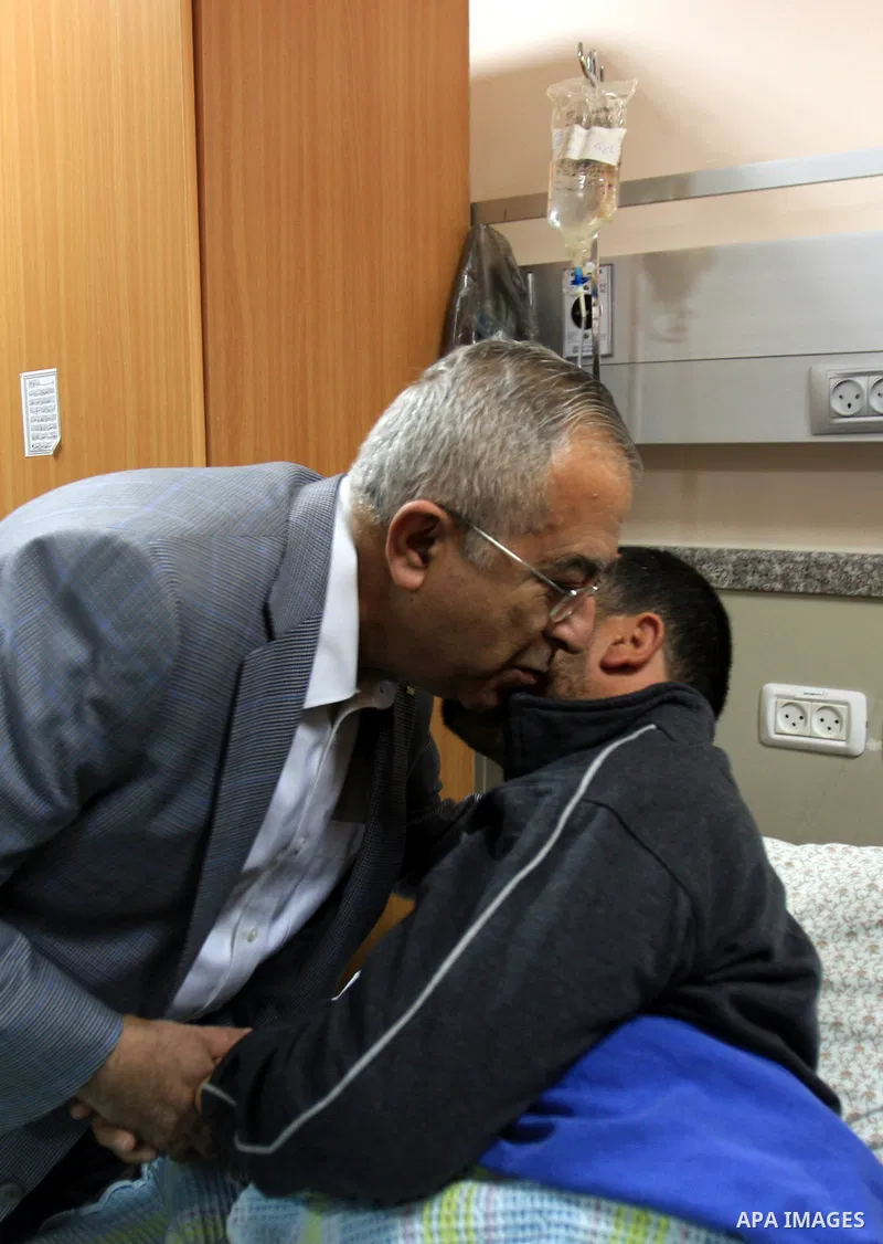 Palestinian Prime Minister Salam Fayyad visits the wounded Palestinians who injured during attack by Israeli settlers, at Rafidia hospital in the West Bank city of Nablus ,Tuesday, March 8, 2011. Jewish settlers opened f...