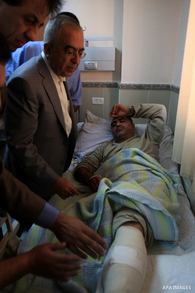Palestinian Prime Minister Salam Fayyad visits the wounded Palestinians who injured during attack by Israeli settlers, at Rafidia hospital in the West Bank city of Nablus ,Tuesday, March 8, 2011. Jewish settlers opened f...