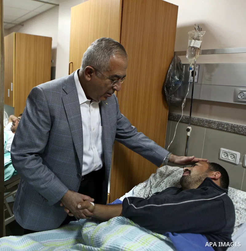 Palestinian Prime Minister Salam Fayyad pays a visit to Rafidya hospital in the West Bank city of Nablus on 08 March 2011, to meet some of the ten Palestinians wounded during the previous day clashes with Jewish settlers...