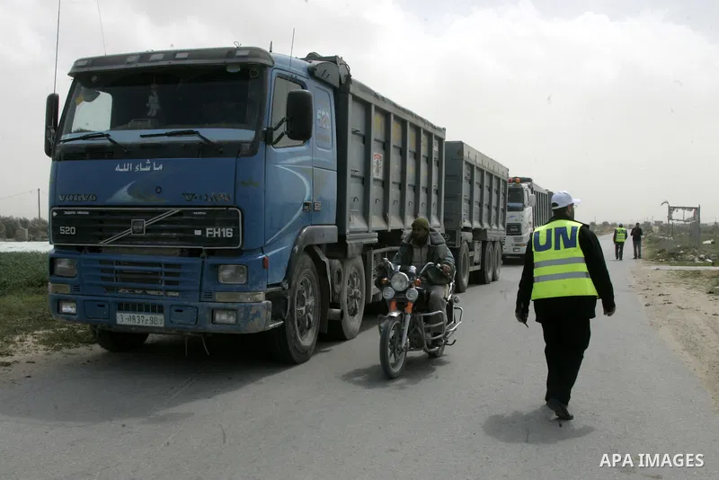 Workers from the United Nations Relief and Works Agency (UNRWA) supervise trucks loaded with gravels at the Sufa border crossing with Israel in the southern Gaza Strip, on March 9, 2011. Israel today allowed gravels to t...
