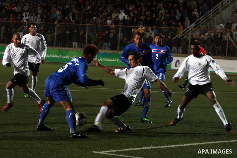 Palestinian (white) and Thailand national football players fight for the ball during their qualifier match for the Asian group of the 2012 London Olympics on March 9, 2011 at the Faisal Husseini stadium in the West Bank...