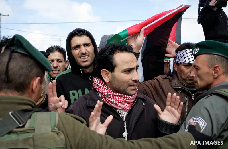Protesters argue with Israeli soldiers during a demonstration against Israel's controversial separation barrier in the West Bank village of Maasarah, near the biblical town of Bethlehem on March 11, 2011.Israel says the...