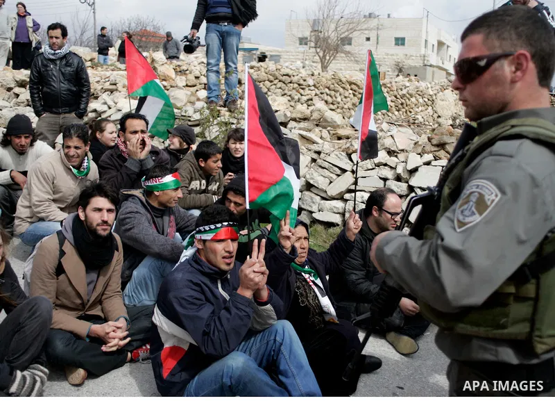 Protesters argue with Israeli soldiers during a demonstration against Israel's controversial separation barrier in the West Bank village of Maasarah, near the biblical town of Bethlehem on March 11, 2011.Israel says the...