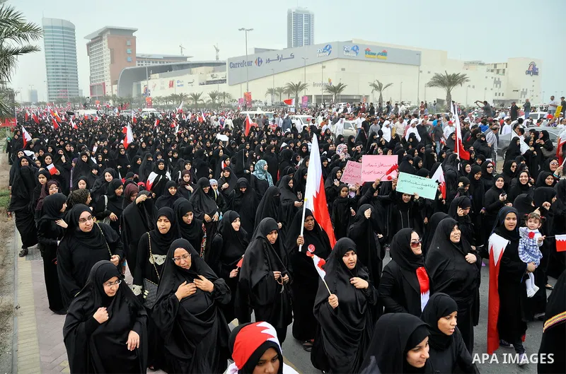 Thousands of Bahraini anti-government demonstrators chant slogans against the king on March 11, 2011 as they march toward the royal palace in Manama where a group of pro-regime loyalists waited with clubs, swords and met...