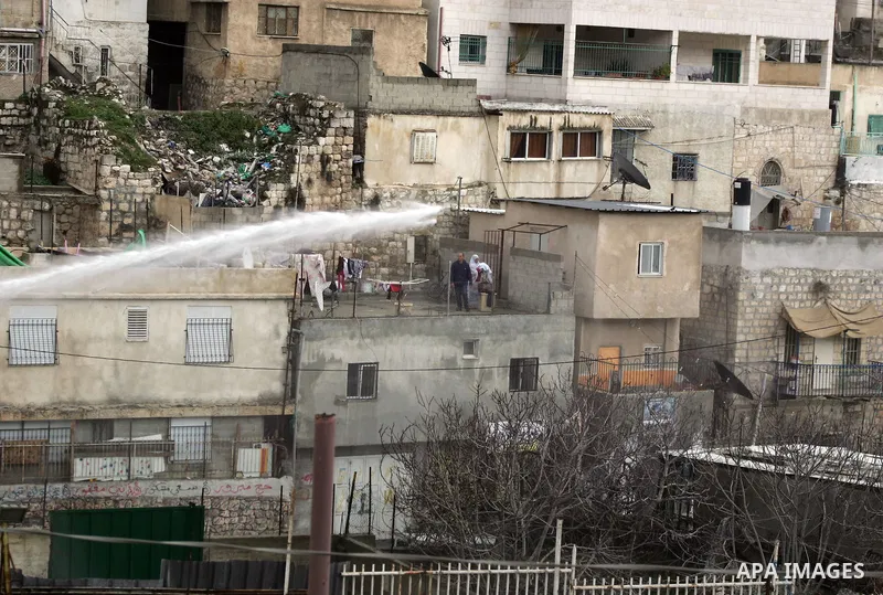 Tear gas canisters fall near Palestinian stone-throwers during clashes with Israeli security forces, not pictured, in the east Jerusalem neighborhood of Silwan, Friday, March 11, 2011.Photo by Mahfouz Abu Turk