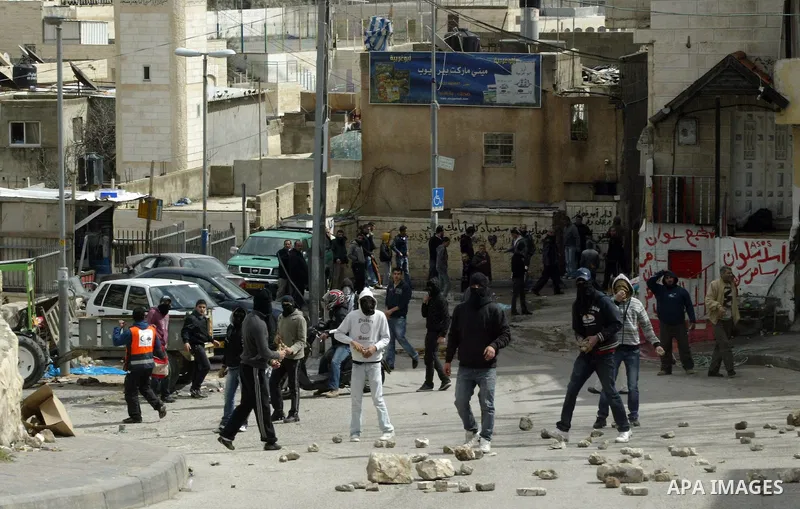 Palestinian youths throw rocks during clashes with Israeli security forces in East Jerusalem, on March 11, 2011.Photo by Mahfouz Abu Turk