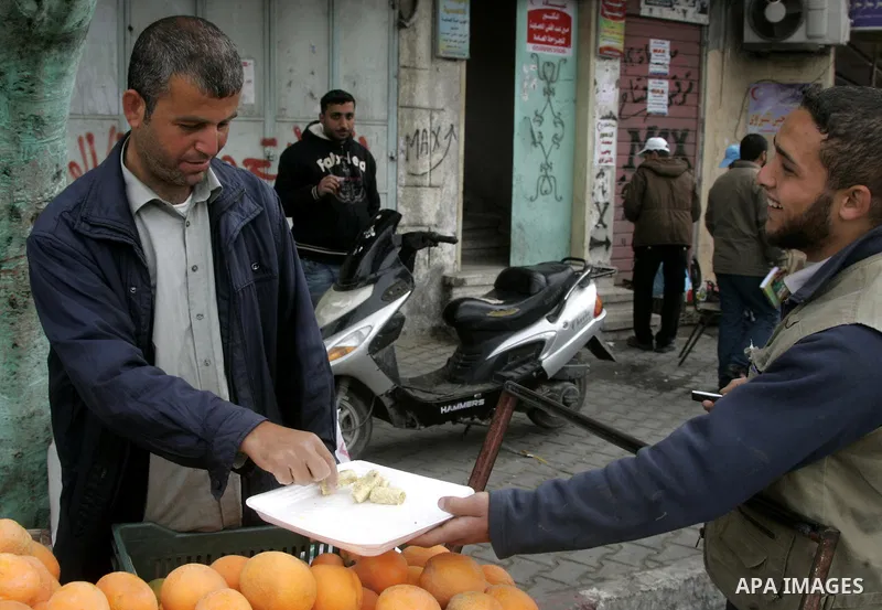 Palestinians distribute desserts celebrating the attack at the Jewish settlement of Itmar near Nablus in Rafah on March 12, 2011. A Palestinian infiltrated Itamar early Saturday and killed five people, the Israeli milita...
