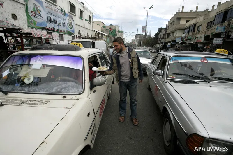 Palestinians distribute desserts celebrating the attack at the Jewish settlement of Itmar near Nablus in Rafah on March 12, 2011. A Palestinian infiltrated Itamar early Saturday and killed five people, the Israeli milita...