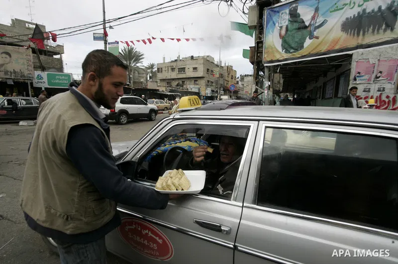 Palestinians distribute desserts celebrating the attack at the Jewish settlement of Itmar near Nablus in Rafah on March 12, 2011. A Palestinian infiltrated Itamar early Saturday and killed five people, the Israeli milita...