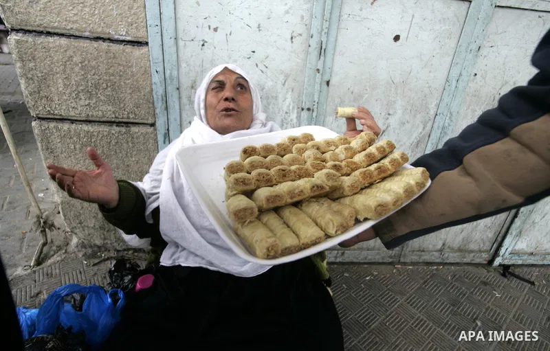 Palestinians distribute desserts celebrating the attack at the Jewish settlement of Itmar near Nablus in Rafah on March 12, 2011. A Palestinian infiltrated Itamar early Saturday and killed five people, the Israeli milita...