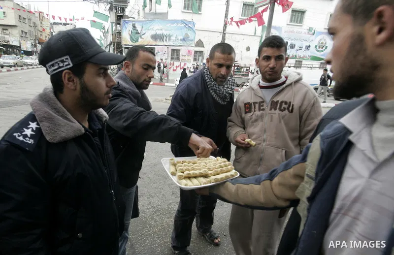 Palestinians distribute desserts celebrating the attack at the Jewish settlement of Itmar near Nablus in Rafah on March 12, 2011. A Palestinian infiltrated Itamar early Saturday and killed five people, the Israeli milita...