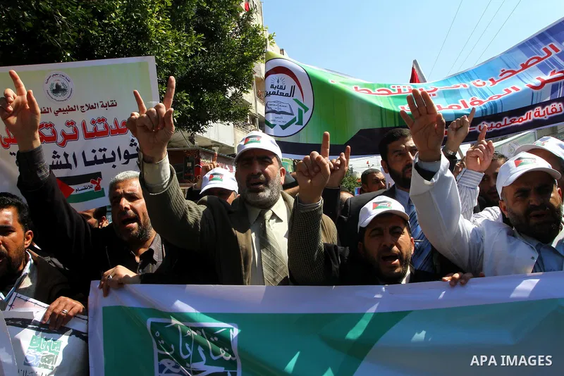 Palestinians hold signs during a protest calling for a national reconciliation between the tow parties Fatah and Hamas in Gaza City on March 12, 2011. Photo by Ashraf Amra
