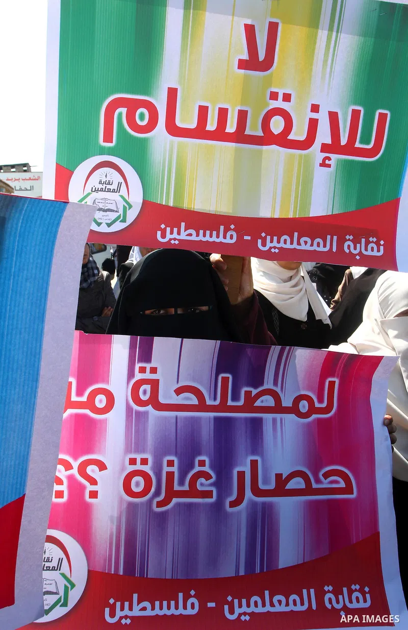 Palestinians hold signs during a protest calling for a national reconciliation between the tow parties Fatah and Hamas in Gaza City on March 12, 2011. Photo by Ashraf Amra