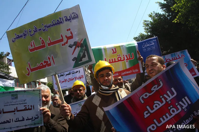Palestinians hold signs during a protest calling for a national reconciliation between the tow parties Fatah and Hamas in Gaza City on March 12, 2011. Photo by Ashraf Amra