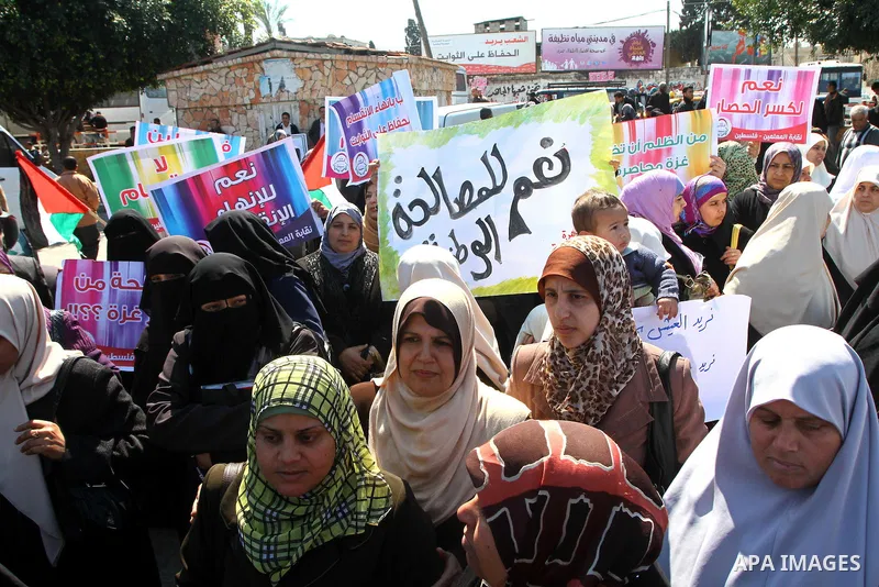 Palestinians hold signs during a protest calling for a national reconciliation between the tow parties Fatah and Hamas in Gaza City on March 12, 2011. Photo by Ashraf Amra