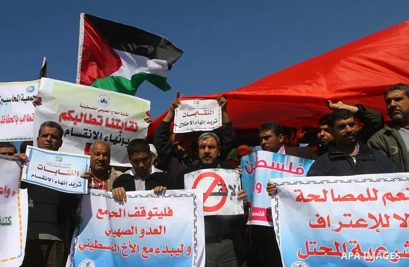 Palestinians hold signs during a protest calling for a national reconciliation between the tow parties Fatah and Hamas in Gaza City on March 12, 2011. Photo by Ashraf Amra