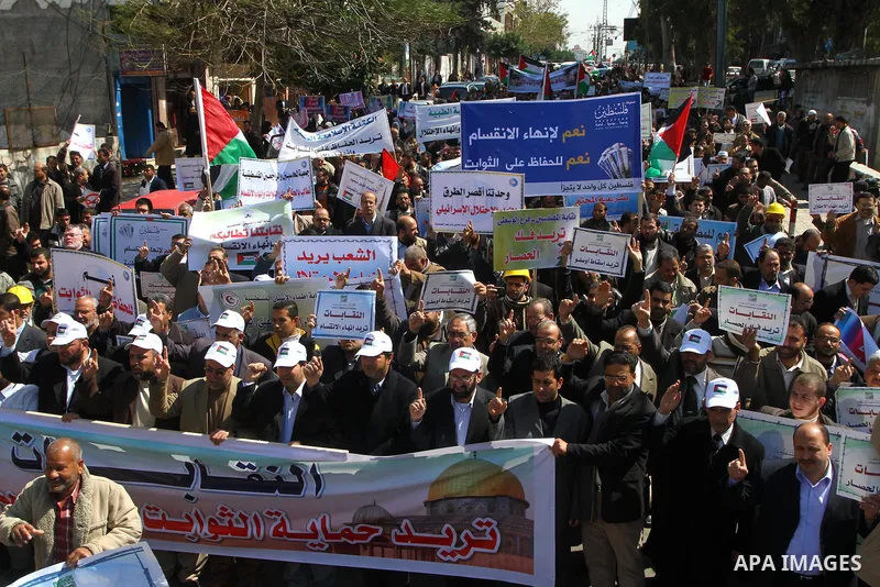 Palestinians hold signs during a protest calling for a national reconciliation between the tow parties Fatah and Hamas in Gaza City on March 12, 2011. Photo by Ashraf Amra