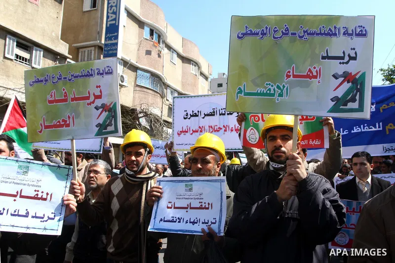 Palestinians hold signs during a protest calling for a national reconciliation between the tow parties Fatah and Hamas in Gaza City on March 12, 2011. Photo by Ashraf Amra