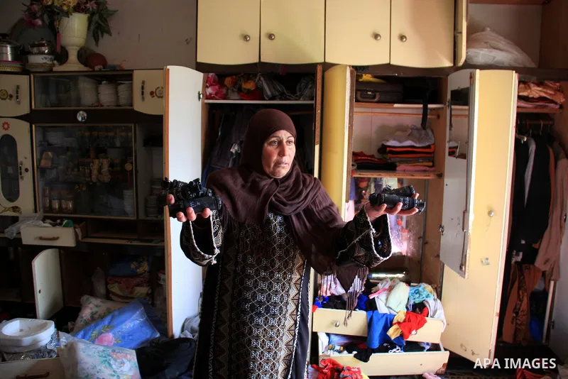 A Palestinian woman inspects damaged room after Israeli army stormed her house, arrested four of her sons in the West Bank village of Awarta near Nablus on March 12, 2011. The Israeli army arrested at least 18 Palestinia...