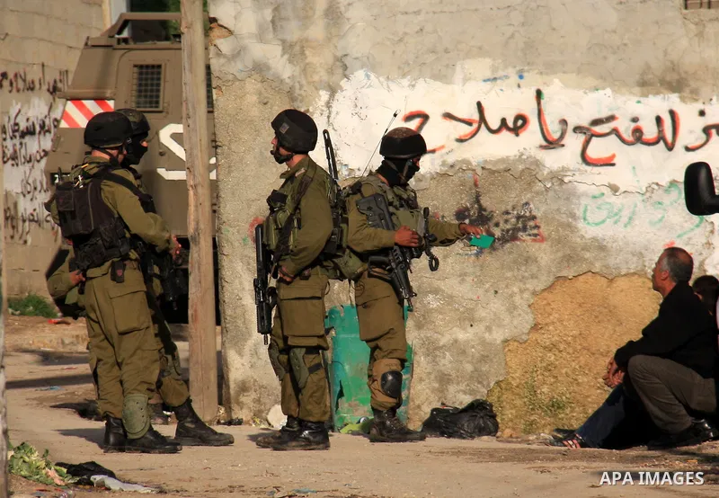 Israeli soldiers take position at Awarta Village south of the West Bank city of Nablus during a search operation on 12 March ,2011. The Israeli army announced the Palestinian city as closed military zone following the ki...