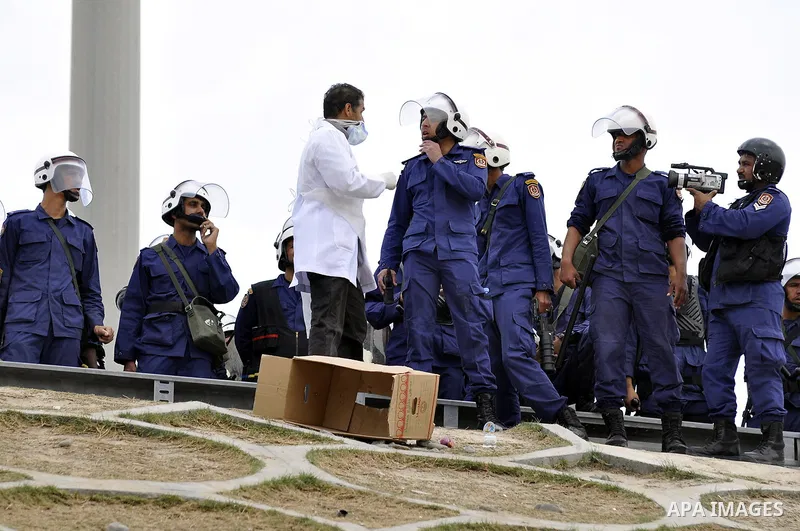 Bahraini anti-government protesters demonstrate in front of riot police on an overpass near Pearl roundabout Sunday, March 13, 2011, in Manama, Bahrain. Photo by Ammar A.rasool