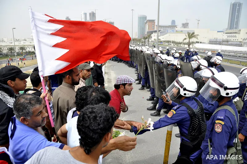 Bahraini anti-government protesters demonstrate in front of riot police on an overpass near Pearl roundabout Sunday, March 13, 2011, in Manama, Bahrain. Photo by Ammar A.rasool