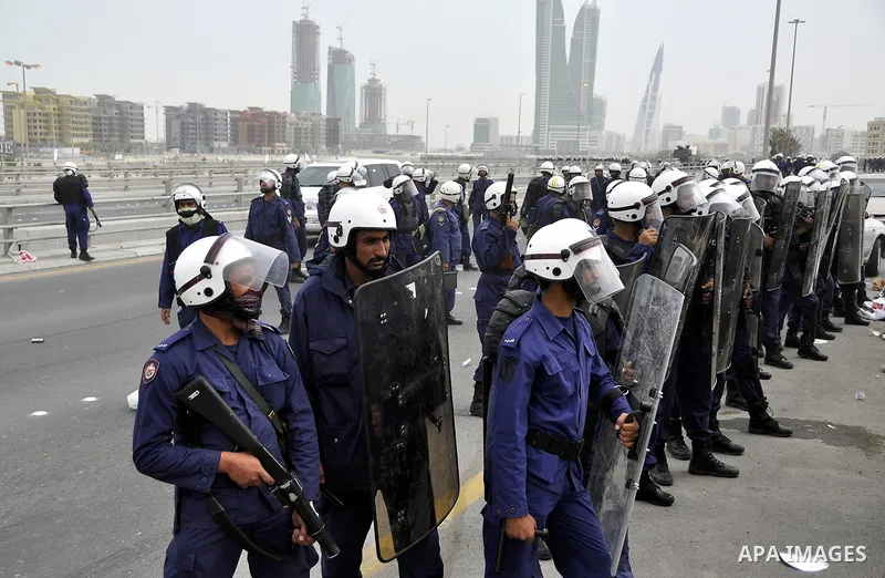 Bahraini anti-government protesters demonstrate in front of riot police on an overpass near Pearl roundabout Sunday, March 13, 2011, in Manama, Bahrain. Photo by Ammar A.rasool