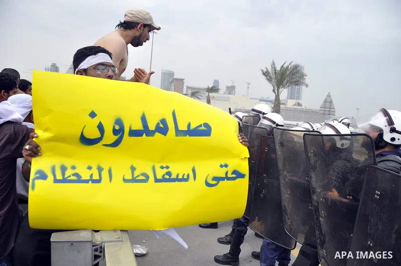 Bahraini anti-government protesters demonstrate in front of riot police on an overpass near Pearl roundabout Sunday, March 13, 2011, in Manama, Bahrain. Photo by Ammar A.rasool