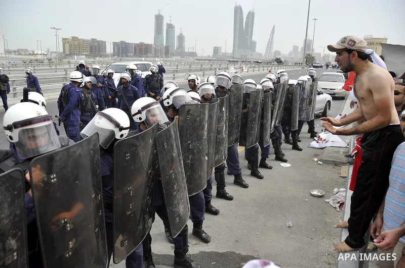 Bahraini anti-government protesters demonstrate in front of riot police on an overpass near Pearl roundabout Sunday, March 13, 2011, in Manama, Bahrain. Photo by Ammar A.rasool