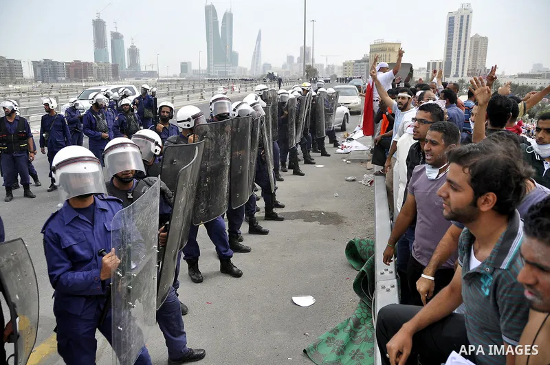 Bahraini anti-government protesters demonstrate in front of riot police on an overpass near Pearl roundabout Sunday, March 13, 2011, in Manama, Bahrain. Photo by Ammar A.rasool