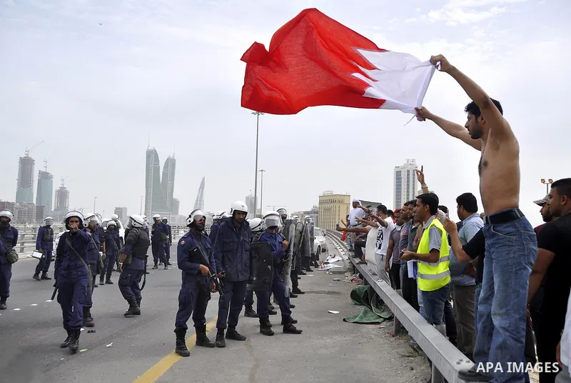 Bahraini anti-government protesters demonstrate in front of riot police on an overpass near Pearl roundabout Sunday, March 13, 2011, in Manama, Bahrain. Photo by Ammar A.rasool