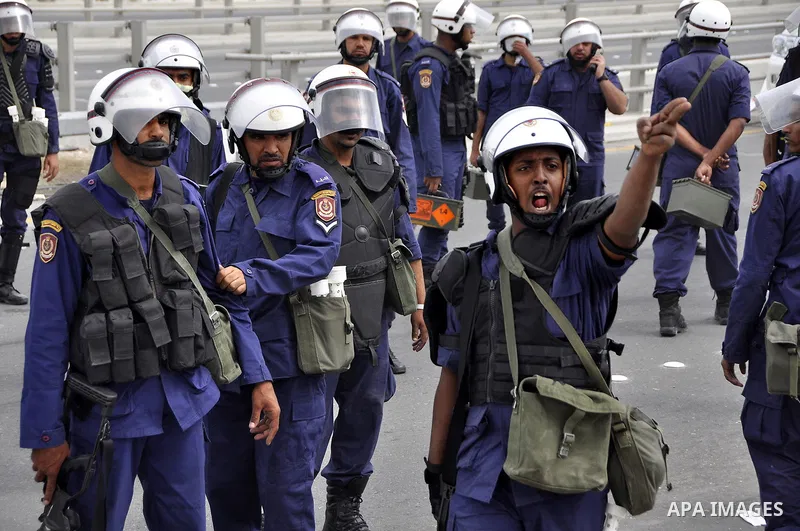 Bahraini anti-government protesters demonstrate in front of riot police on an overpass near Pearl roundabout Sunday, March 13, 2011, in Manama, Bahrain. Photo by Ammar A.rasool