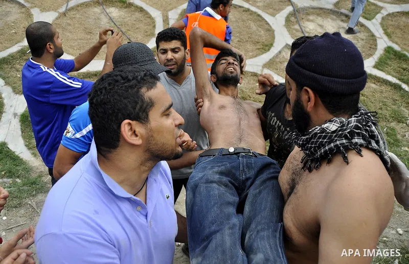 Anti-government protesters carry away a fellow demonstrator who was overcome by tear gas fired by riot police Sunday, March 13, 2011, along a main highway in Manama, Bahrain. Photo by Ammar A.rasool