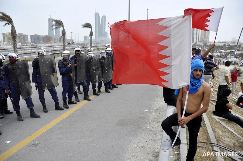 Bahraini anti-government protesters demonstrate in front of riot police on an overpass near Pearl roundabout Sunday, March 13, 2011, in Manama, Bahrain. Photo by Ammar A.rasool