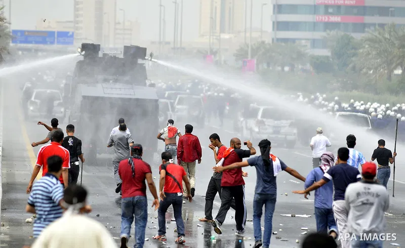 Anti-government protesters react to tear gas fired by riot police Sunday, March 13, 2011, along a main highway in Manama, Bahrain. Photo by Ammar A.rasool