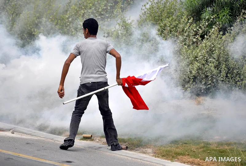 Anti-government protesters react to tear gas fired by riot police Sunday, March 13, 2011, along a main highway in Manama, Bahrain. Photo by Ammar A.rasool