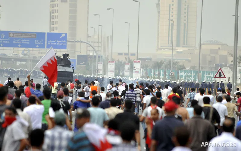Anti-government protesters react to tear gas fired by riot police Sunday, March 13, 2011, along a main highway in Manama, Bahrain. Photo by Ammar A.rasool